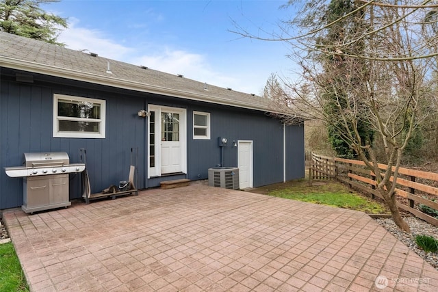 rear view of house with cooling unit, a patio area, and fence