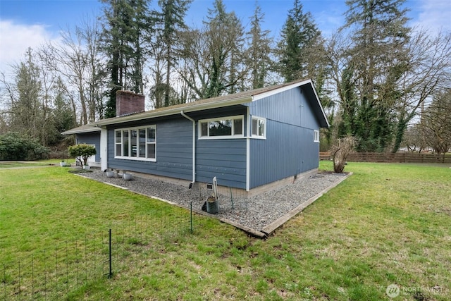 view of property exterior featuring a yard and a chimney