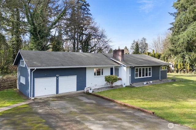 ranch-style home with aphalt driveway, a front lawn, an attached garage, and a chimney