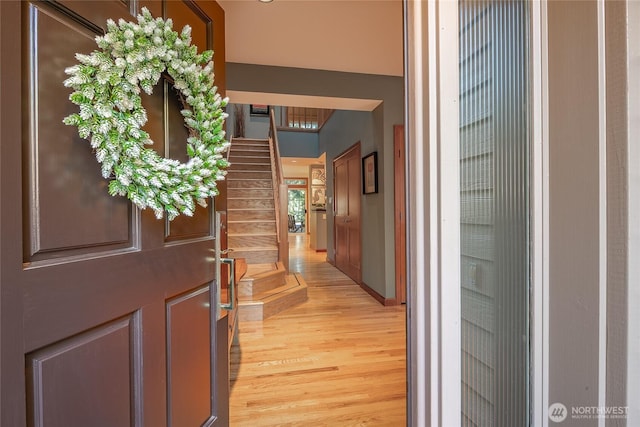 interior space with baseboards, stairs, and light wood-style floors