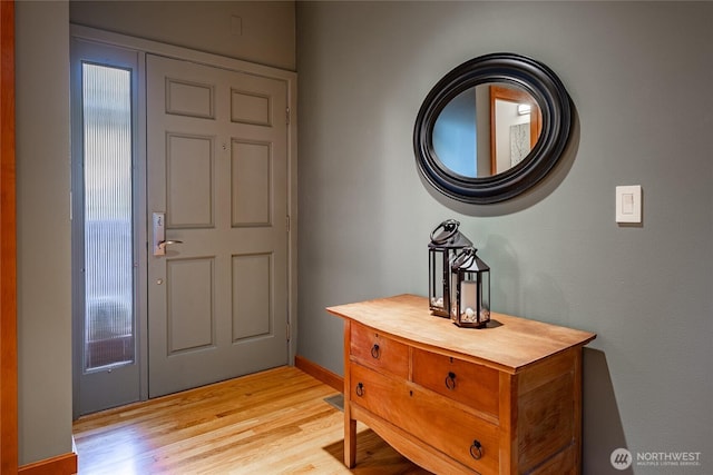 entryway with baseboards and light wood finished floors