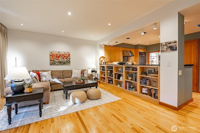 living area with light wood-style flooring, recessed lighting, and baseboards