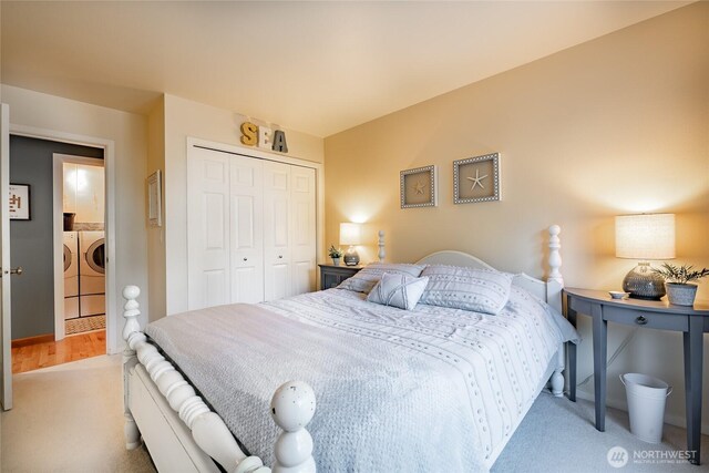 carpeted bedroom with a closet and separate washer and dryer