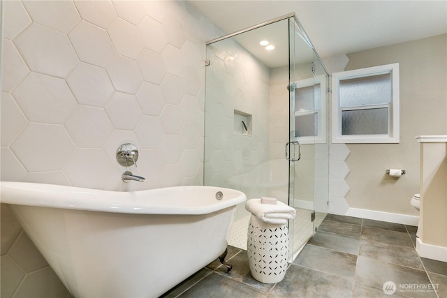 bathroom featuring a shower stall, recessed lighting, a freestanding tub, tile patterned floors, and tile walls