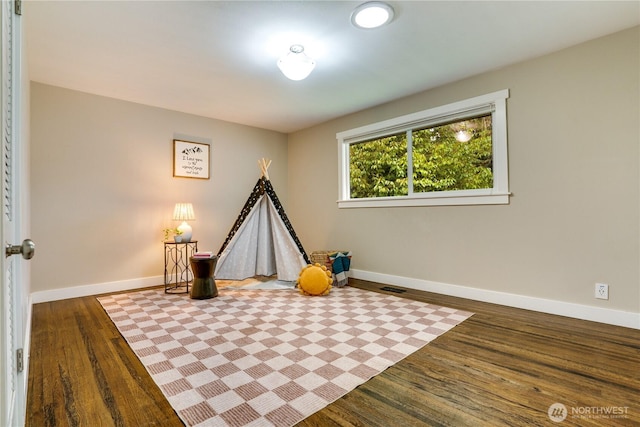 rec room featuring visible vents, baseboards, and wood finished floors