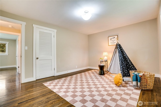 playroom featuring baseboards and wood finished floors