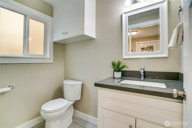 bathroom with vanity, toilet, baseboards, and tile patterned flooring