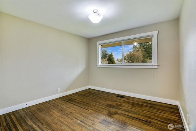 unfurnished room featuring visible vents, baseboards, and dark wood-type flooring