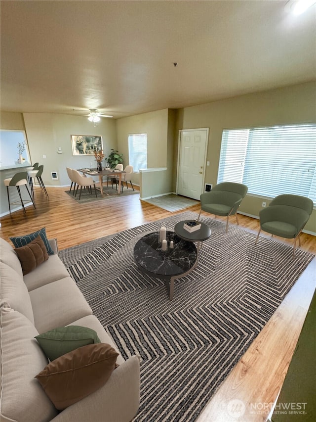 living room featuring wood finished floors, a wealth of natural light, and baseboards