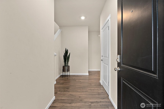 hall featuring recessed lighting, baseboards, and wood finished floors