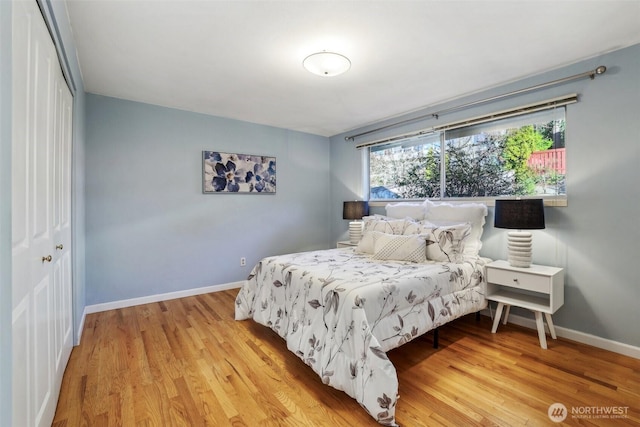 bedroom featuring light wood finished floors, a closet, and baseboards