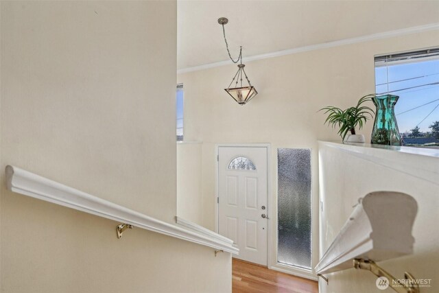 entryway featuring light wood-style floors and ornamental molding