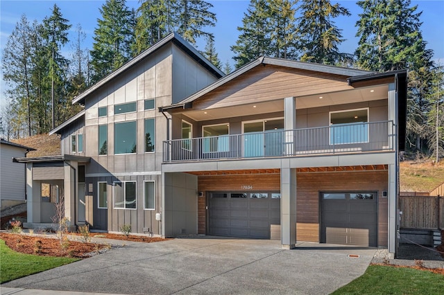 modern home featuring an attached garage, a balcony, board and batten siding, and concrete driveway