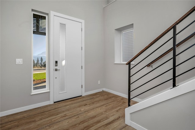 foyer with baseboards, stairway, and wood finished floors