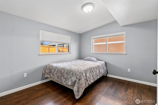 bedroom featuring hardwood / wood-style flooring, baseboards, and vaulted ceiling