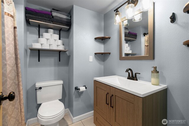 full bath with toilet, tile patterned flooring, baseboards, and vanity