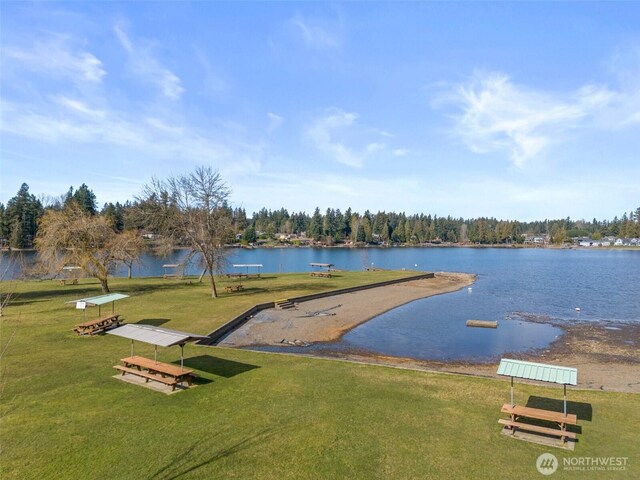 view of community featuring a lawn and a water view