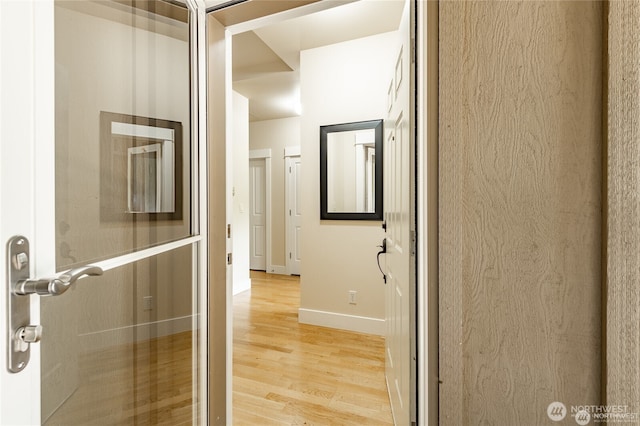 hall featuring light wood-style floors and baseboards