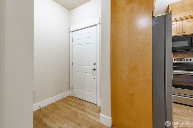 entryway with light wood-style flooring and baseboards