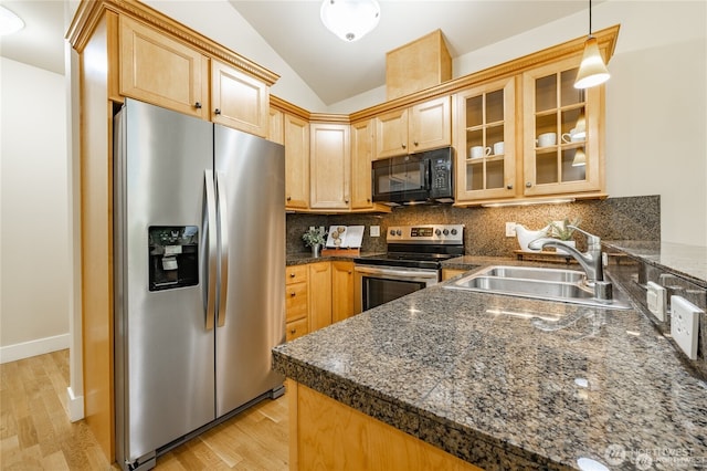 kitchen with stainless steel appliances, lofted ceiling, dark countertops, tasteful backsplash, and a sink