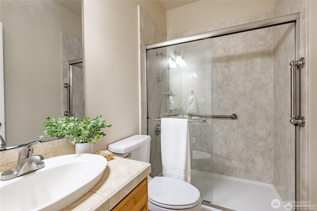 full bath featuring a stall shower, vanity, and toilet