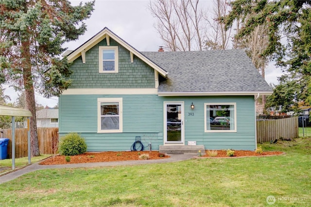 view of front facade with a chimney, roof with shingles, a front yard, and fence