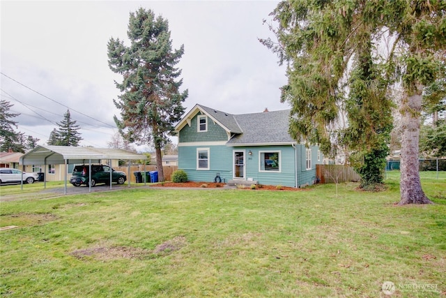 view of front of house featuring fence, roof with shingles, a front yard, a carport, and a chimney