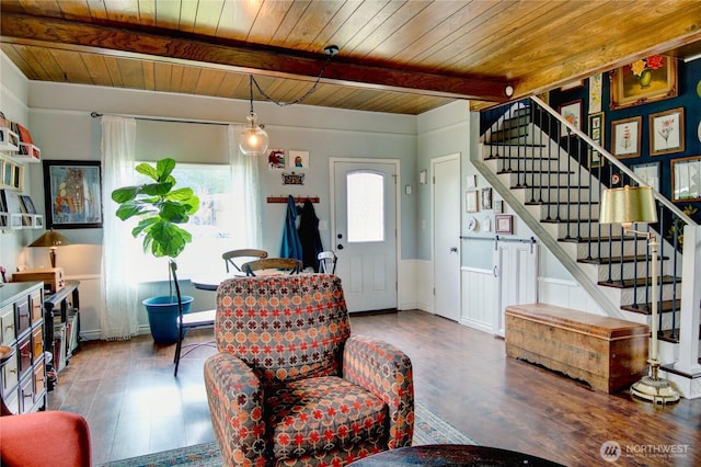 living room featuring wood finished floors, stairs, wood ceiling, wainscoting, and beamed ceiling