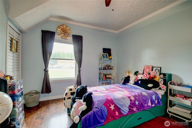 bedroom with a textured ceiling, wood finished floors, a ceiling fan, and vaulted ceiling