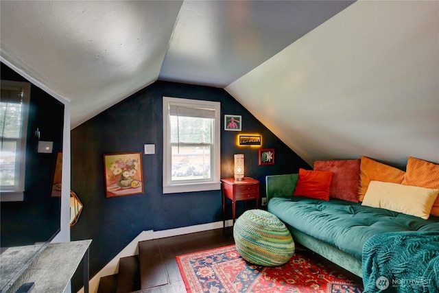 interior space featuring vaulted ceiling, wood finished floors, and baseboards