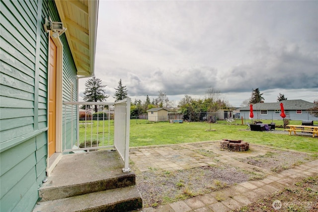 view of yard featuring a patio, a fire pit, and fence