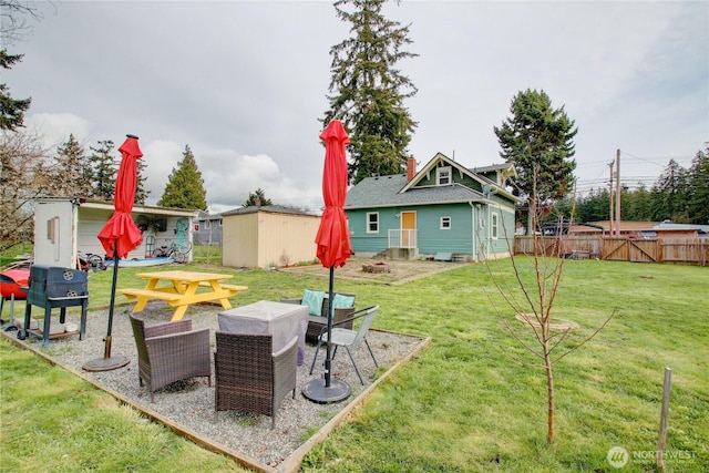 view of yard featuring an outbuilding, a storage shed, and fence