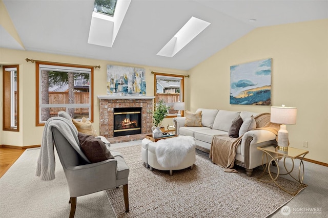 living room with lofted ceiling with skylight, a brick fireplace, and baseboards