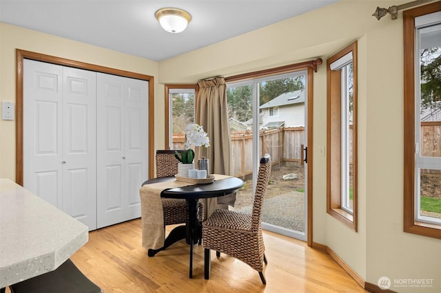 dining area with light wood-type flooring and baseboards