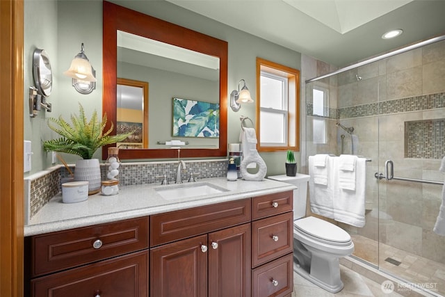 full bath featuring backsplash, a stall shower, vanity, and toilet