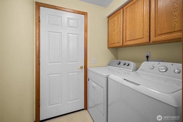 laundry room with cabinet space, washing machine and dryer, and light floors