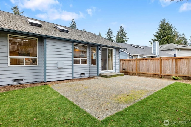 rear view of property with crawl space, a patio, a yard, and fence