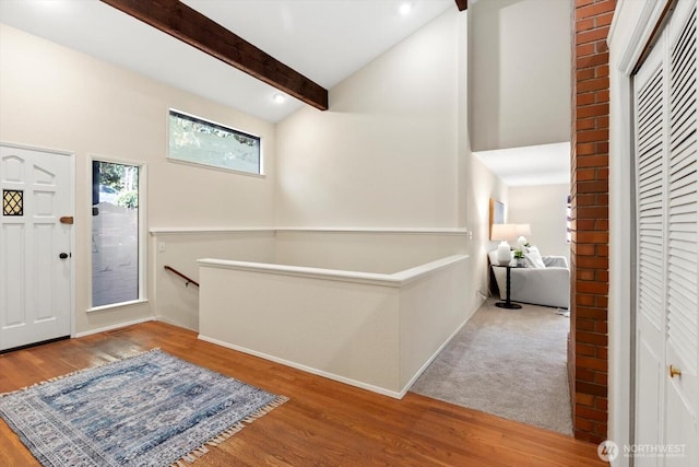 foyer entrance featuring high vaulted ceiling, beamed ceiling, and wood finished floors