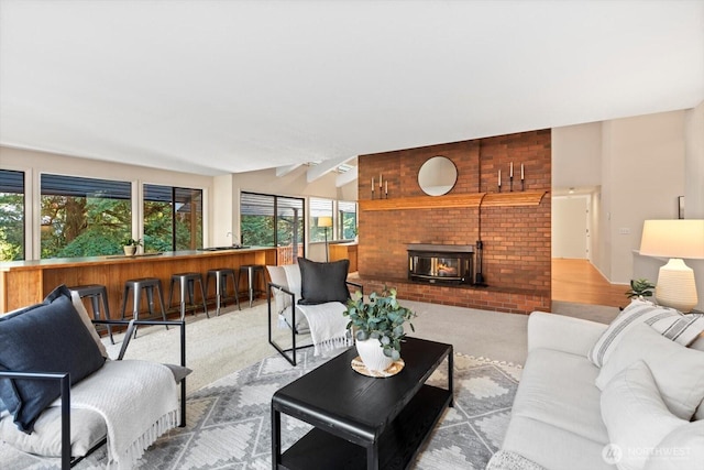 living room with vaulted ceiling, carpet floors, and a fireplace