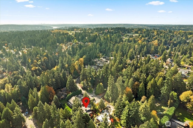 drone / aerial view featuring a wooded view