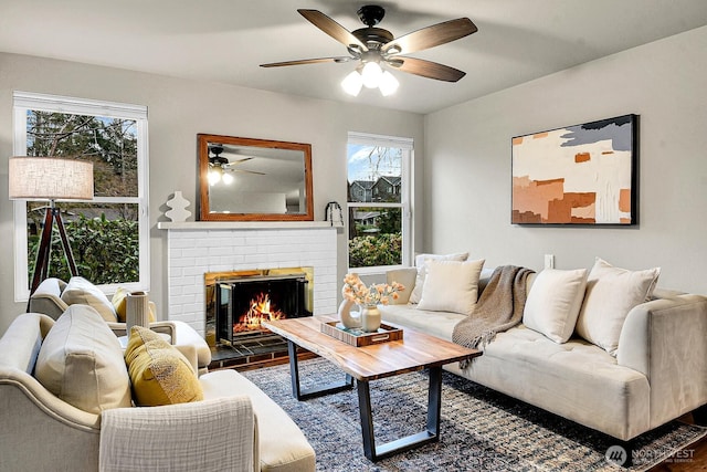 living room featuring a brick fireplace and ceiling fan