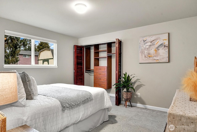 bedroom featuring light colored carpet, a closet, and baseboards