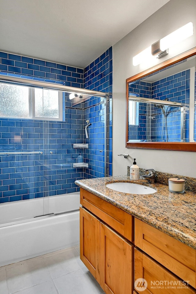 full bath featuring tile patterned flooring, vanity, and bath / shower combo with glass door