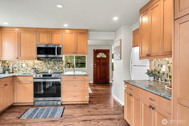 kitchen featuring light stone counters, tasteful backsplash, wood finished floors, recessed lighting, and appliances with stainless steel finishes