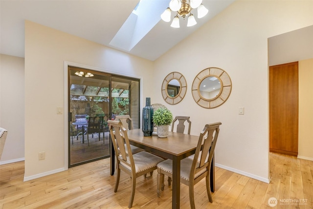 dining space featuring lofted ceiling with skylight, light wood-style flooring, and baseboards