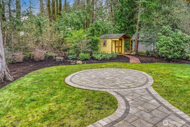 view of yard featuring an outbuilding, a storage unit, and a patio