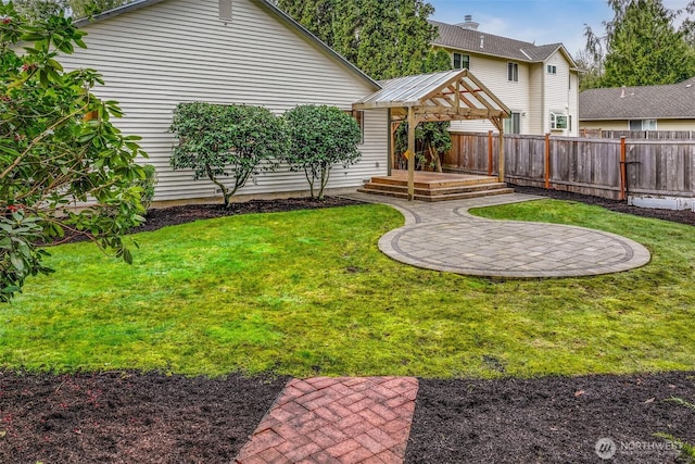 view of yard featuring a gazebo, a wooden deck, a patio, and fence