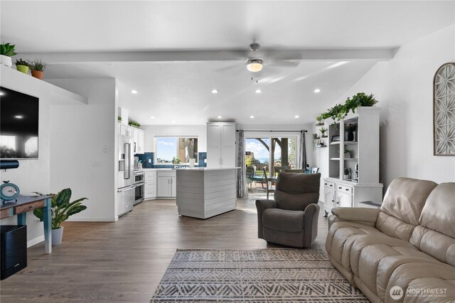 living area featuring a ceiling fan, wood finished floors, baseboards, vaulted ceiling with beams, and recessed lighting