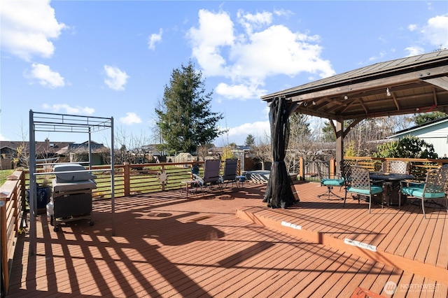 wooden terrace with a gazebo and a grill