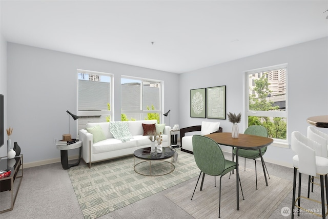 living area with baseboards and light colored carpet